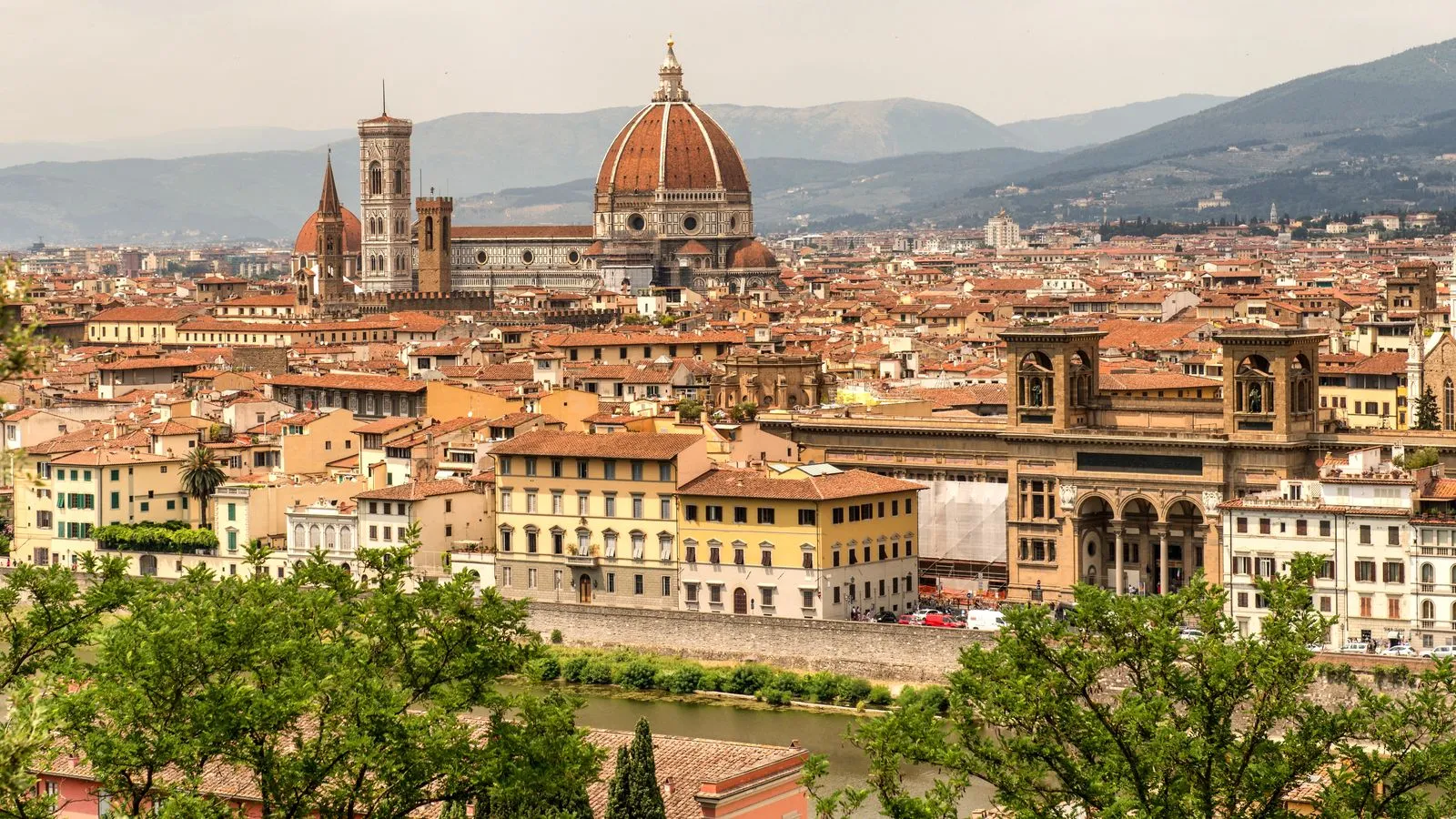 The rooftops of Florence with the dome of the cathedral and Giotto's bell tower, seen from across the Arno with hills behind