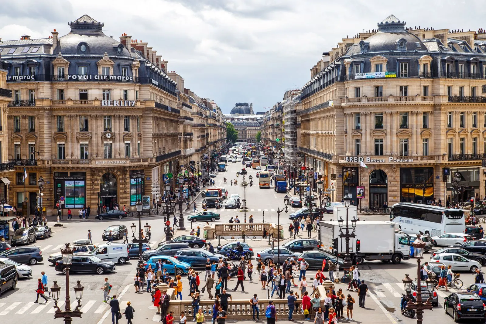 Avenue de l'Opéra in Paris seen from the Opéra Garnier, lined with Haussmann buildings and busy with traffic and pedestrians
